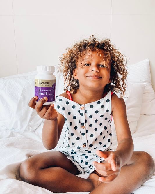 Kid holding up Renzo's Picky Eater Multivitamin for kids that includes methylated vitamins for kids.