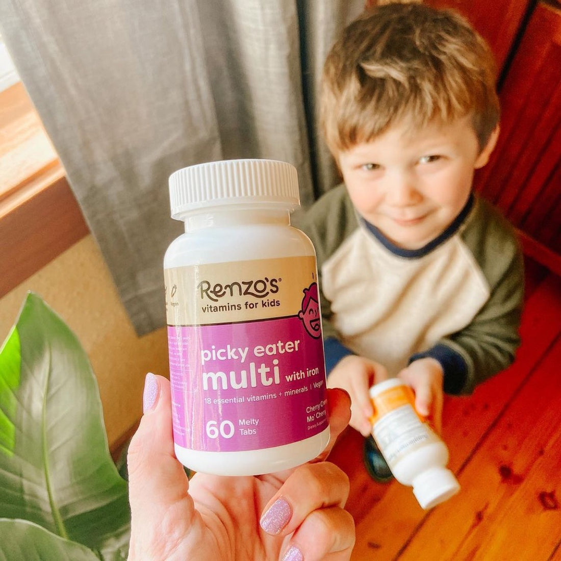 Picture of parent safely giving her child Renzo's Picky Eater Multivitamin