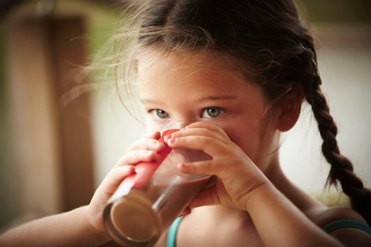 Kid drinking a healthy smoothie. Discover 4 delicious and healthy smoothie recipes for picky eaters.